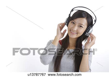 Stock Photo - "Young girl listening music and smiling, portrait". Fotosearch