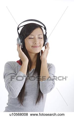 Stock Photo - "Young girl listening music with eyes closed, portrait". Fotosearch