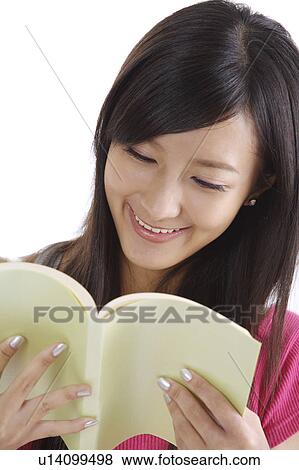 Stock Photo - "Young girl reading book and smiling happily, portrait". Fotosearch