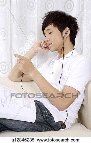 "Young man reading book and listening music, portrait" View Large Photo Image Stock Photography - "Young man reading book and listening music, portrait". Fotosearch