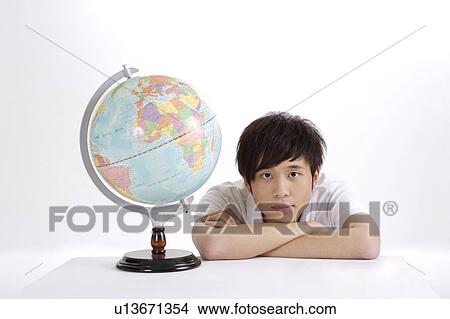 Picture - "Young man sitting with hands on chin, portrait". Fotosearch