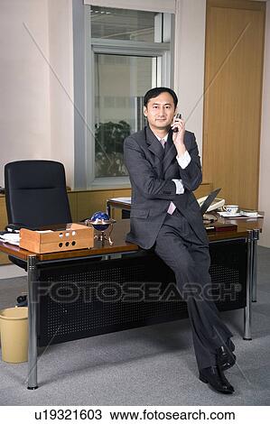 Business man using mobile phone in the office View Large Photo Image Stock Image - Business man using mobile phone in the office. Fotosearch