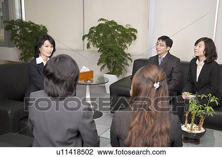 Stock Image - Business people having a meeting and discussing together. Fotosearch