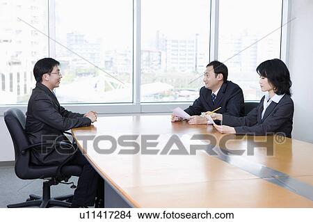 Business people having interview with a young man View Large Photo Image Picture - Business people having interview with a young man. Fotosearch