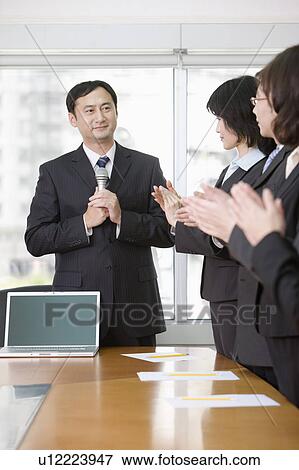 Stock Photo - Business people making a report and clapping. Fotosearch