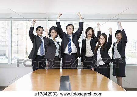 Stock Image - Business people standing with fists up together. Fotosearch