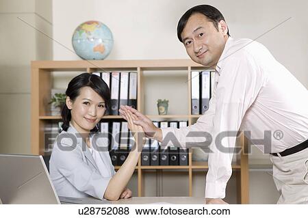 Businessman and businesswoman having high-five and looking at the camera View Large Photo Image Stock Photo - Businessman and businesswoman having high-five and looking at the camera. Fotosearch