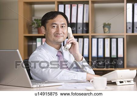 "Businessman looking at the camera and on the phone, portrait" View Large Photo Image Stock Photography - "Businessman looking at the camera and on the phone, portrait". Fotosearch