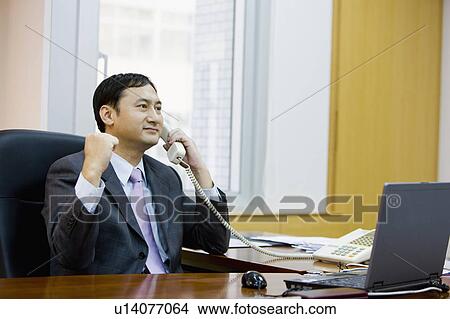 Businessman looking away with one fist up and on the phone View Large Photo Image Picture - Businessman looking away with one fist up and on the phone. Fotosearch