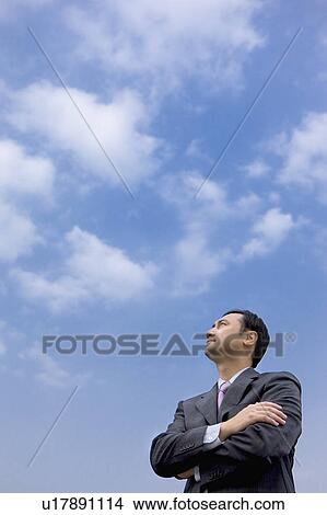 Businessman looking up with hands on chest View Large Photo Image Picture - Businessman looking up with hands on chest. Fotosearch