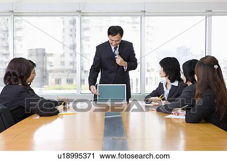 Stock Image - Businessman making report to his colleagues. Fotosearch