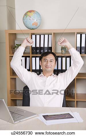 Stock Image - Businessman stretching with hands up. Fotosearch