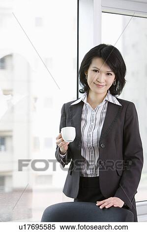 "Businesswoman holding a cup and looking at the camera, portrait" View Large Photo Image Stock Photography - "Businesswoman holding a cup and looking at the camera, portrait". Fotosearch