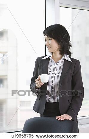 "Businesswoman holding a cup and looking away, portrait" View Large Photo Image Stock Photography - "Businesswoman holding a cup and looking away, portrait". Fotosearch
