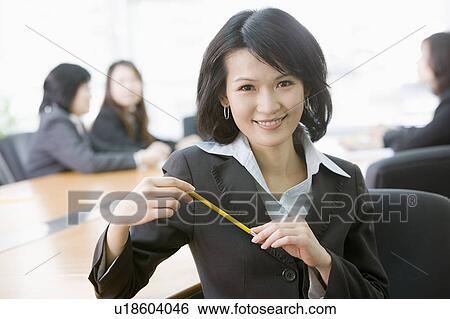"Businesswoman holding a pencil and smiling at the camera, portrait" View Large Photo Image Stock Photograph - "Businesswoman holding a pencil and smiling at the camera, portrait". Fotosearch