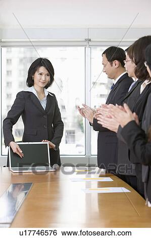 Businesswoman showing report to other colleagues View Large Photo Image Stock Photograph - Businesswoman showing report to other colleagues. Fotosearch
