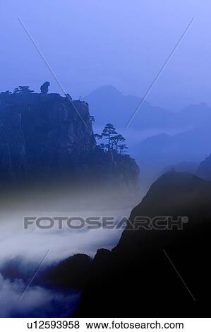 Stock Illustration - Monkey standing on a peak, gazing downwards, Mt Huangshan, digitally enhanced. Fotosearch