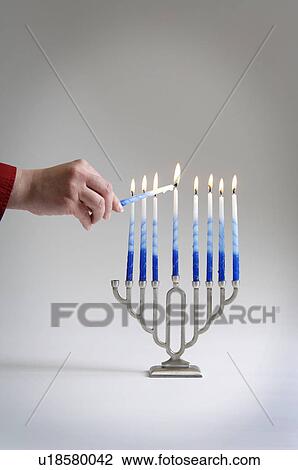 Woman lighting menorah candles View Large Photo Image Stock Image - Woman lighting menorah candles. Fotosearch