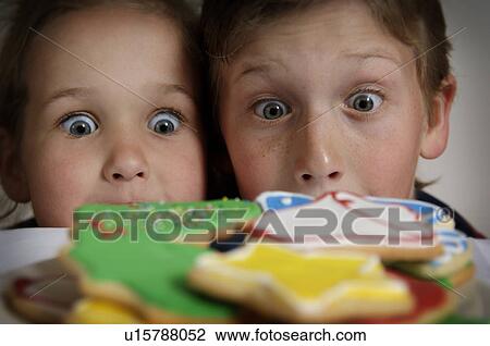 Boy and girl staring at Christmas cookies View Large Photo Image Stock Image - Boy and girl staring at Christmas cookies. Fotosearch