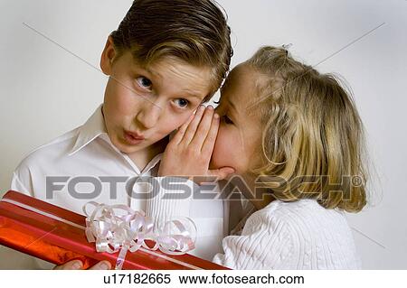 Girl whispering in boy's ear View Large Photo Image Stock Photography - Girl whispering in boy's ear. Fotosearch