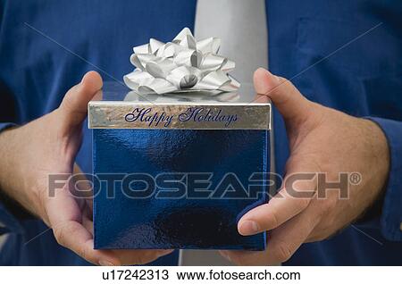 Man holding Christmas gift View Large Photo Image Stock Image - Man holding Christmas gift. Fotosearch