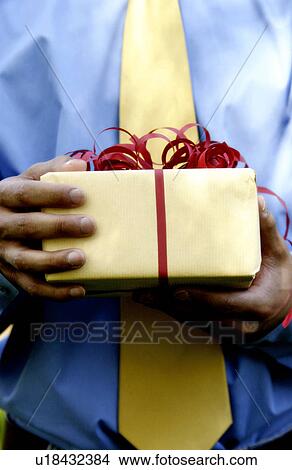 Man holding Christmas present View Large Photo Image Picture - Man holding Christmas present. Fotosearch