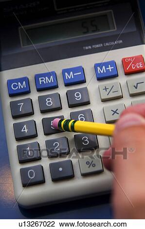 Stock Image - Man using calculator. Fotosearch