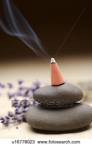 Stock Image - Burning incense on pebbles. Fotosearch
