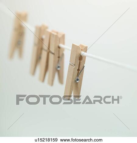 Stock Photo - Clothes pins hanging on a thread. Fotosearch