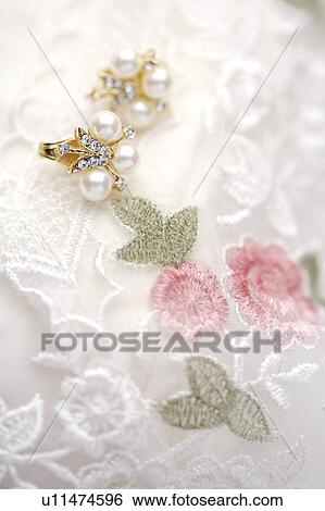 Stock Photograph - Earring on lace. Fotosearch