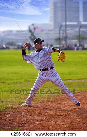 Stock Image - Baseball pitcher preparing to throw ball. Fotosearch