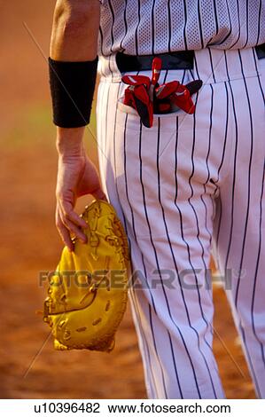 Baseball player holding baseball glove, low section View Large Photo Image Stock Image - Baseball player holding baseball glove, low section. Fotosearch