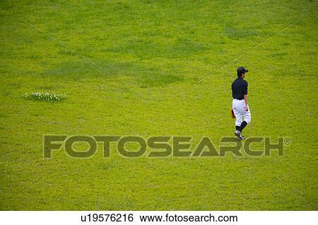 Baseball player walking on grass View Large Photo Image Stock Photograph - Baseball player walking on grass. Fotosearch