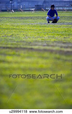 Stock Photo - Player crouching on grass. Fotosearch