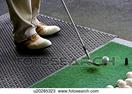 A man hitting golf balls at a driving range View Large Photo Image Stock Image - A man hitting golf balls at a driving range. Fotosearch