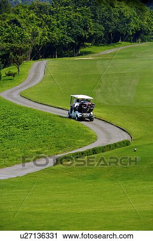 Golfer driving cart on single lane road View Large Photo Image Stock Image - Golfer driving cart on single lane road. Fotosearch