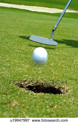 Stock Photo - Person putting (focus on hole). Fotosearch