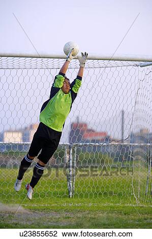 Stock Image - Football goalie diving for ball . Fotosearch
