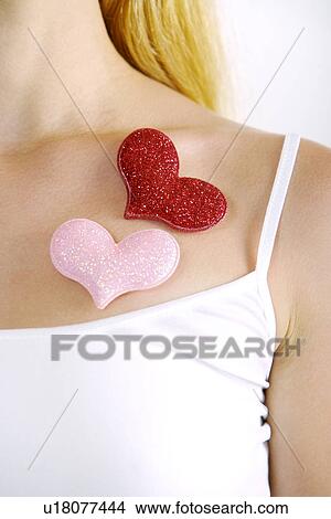 Picture - Heart-shaped objects on young woman's chest. Fotosearch