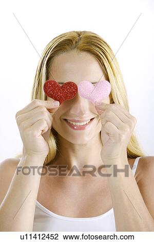 Young woman covering her eyes with two heart shape View Large Photo Image Stock Image - Young woman covering her eyes with two heart shape. Fotosearch
