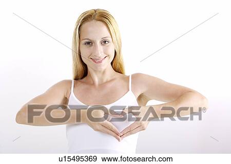 Stock Photo - Young woman making heart-shaped gesture. Fotosearch