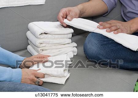Stock Photography - Folding stacks of cloth diapers, Winnipeg, Canada. Fotosearch