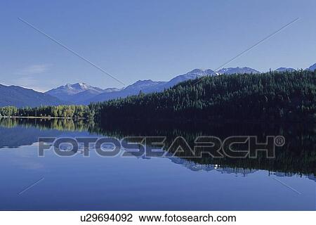 Stock Image - Mountains are reflected in Alta Lake, early autumn. Fotosearch