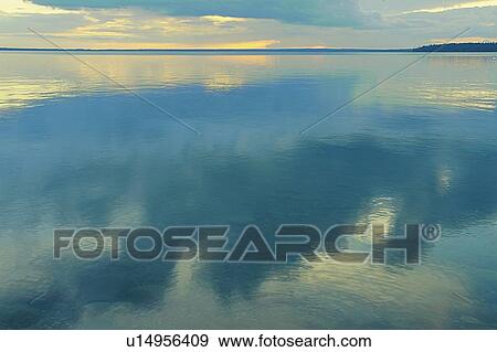 Stock Photo - Reflection of clouds in Clear Lake; Canada, Manitoba, Riding Mountain National Park. Fotosearch