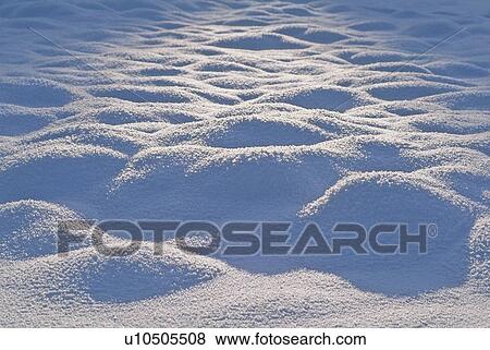 Stock Photo - Low winter sun lights mounds of snow, Whistler, BC. Fotosearch