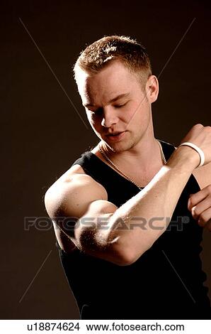 Portrait of young man (21 years of age) showing his bicep; Canada, Saskatchewan, Regina View Large Photo Image Picture - Portrait of young man (21 years of age) showing his bicep; Canada, Saskatchewan, Regina. Fotosearch