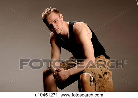 Stock Image - Portrait of young man (21 years of age) showing his prosthesis, having lost lower leg to cancer; Canada, Saskatchewan, Regina. Fotosearch