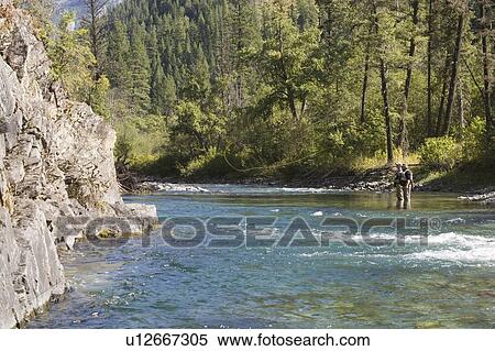 Stock Photography - Fly-fishing guide, Russ Trand, fly-fishing with client on tributary of Elk River near Fernie, Elk Valley, East Kootenays, British Columbia, Canada.. Fotosearch