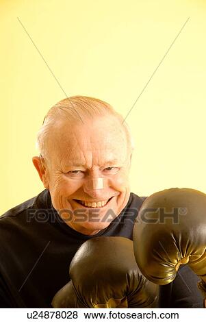 Stock Photo - Senior male boxing gloves; Canada, Saskatchewan, Regina. Fotosearch