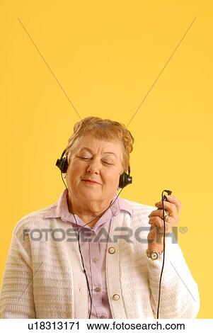 Stock Image - Senior Woman headphones; Canada, Saskatchewan, Regina. Fotosearch